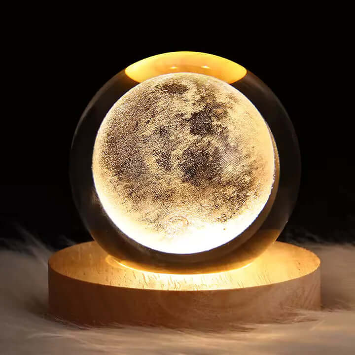 Norillo krystalglobe med måne-design der lyser i et mørkt rum